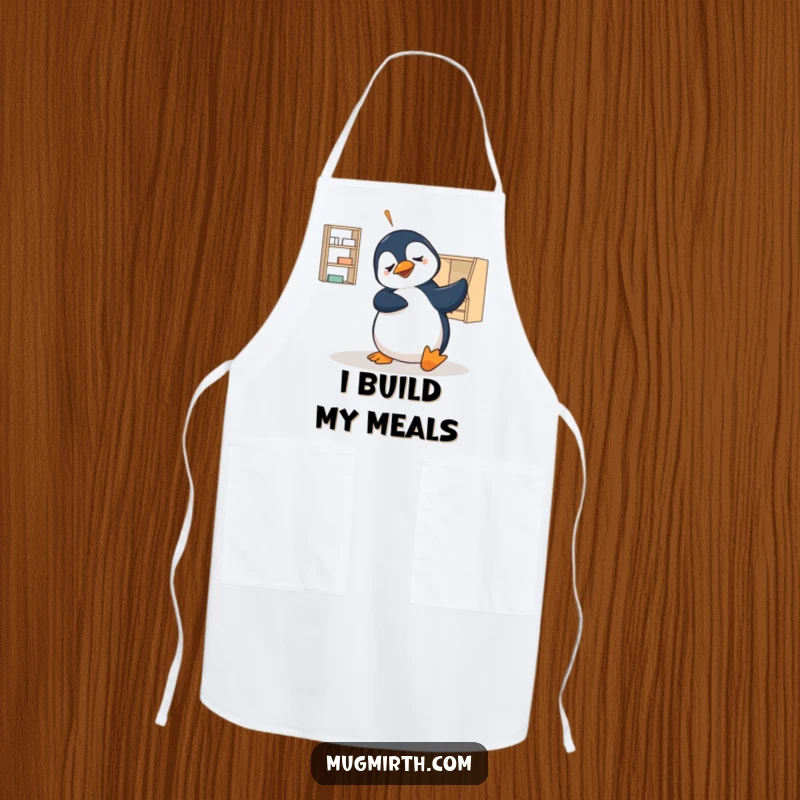 Funny apron featuring a penguin hilariously failing at flat-pack furniture assembly, a humorous kitchen accessory gift.