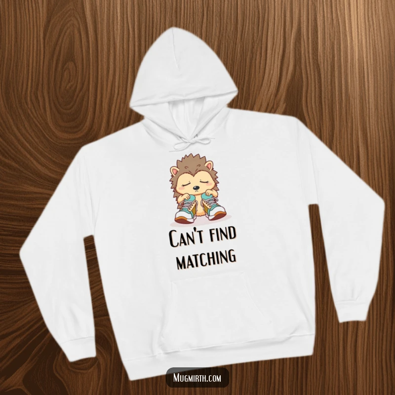 Funny Sleepy Hedgehog Hoodie: A confused hedgehog fumbles with oversize sneakers, radiating cozy bewilderment.