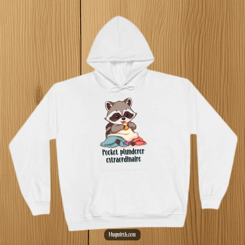 Funny Raccoon Hoodie: A sneaky raccoon, eyes gleaming, clutches a stolen shiny button amidst a pile of discarded clothes.